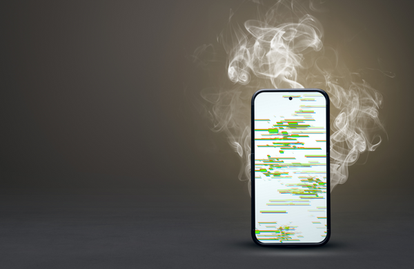 A phone standing upright with smoke coming off of it and displaying a glitching screen 
