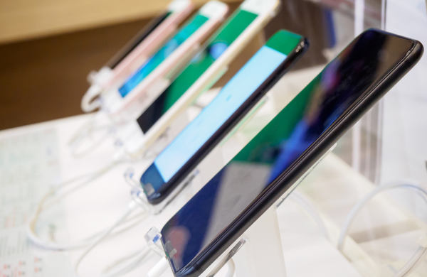 Phones lined up on display in a store.